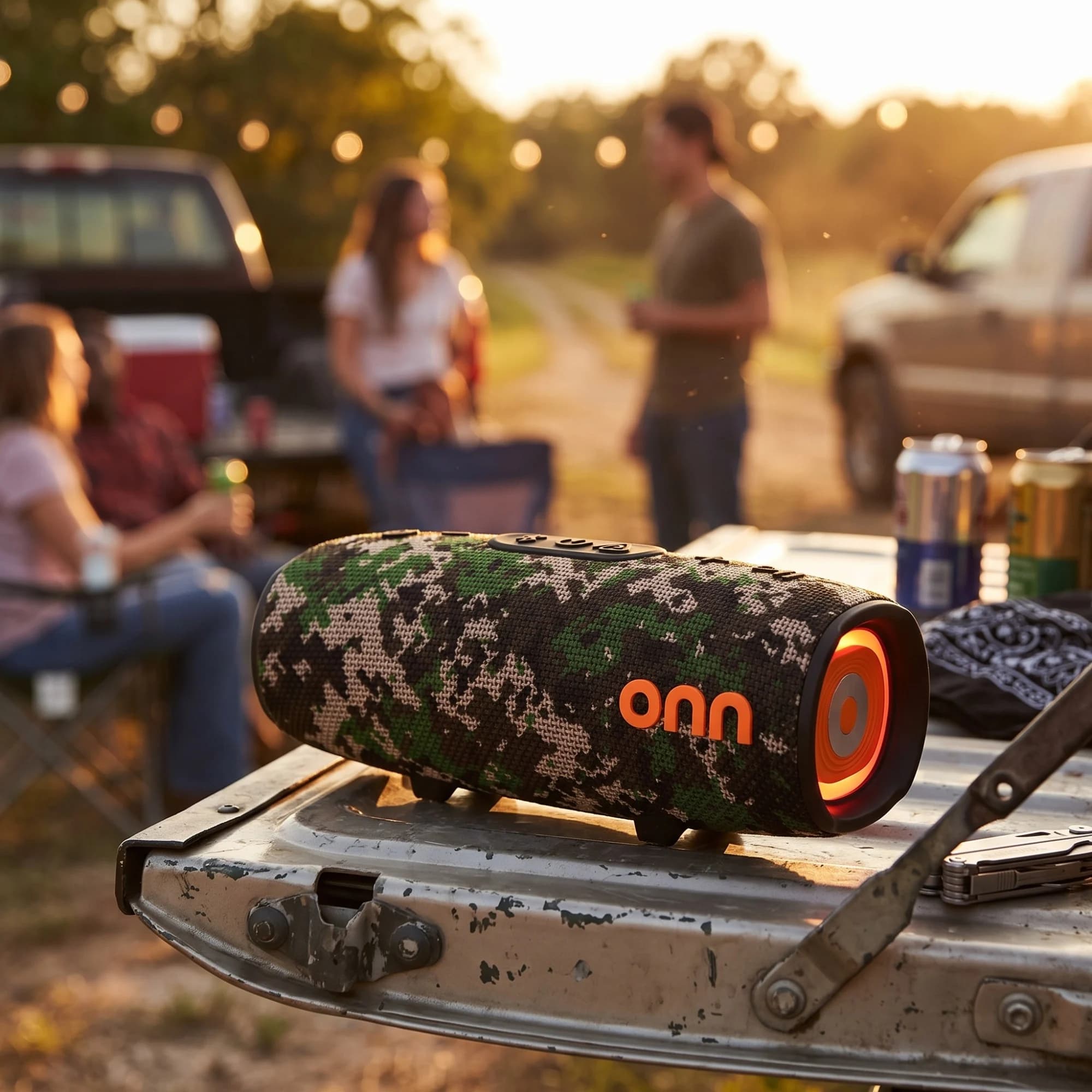 onn. camo rugged speaker on a pickup tailgate at a golden hour party with friends gathered behind it