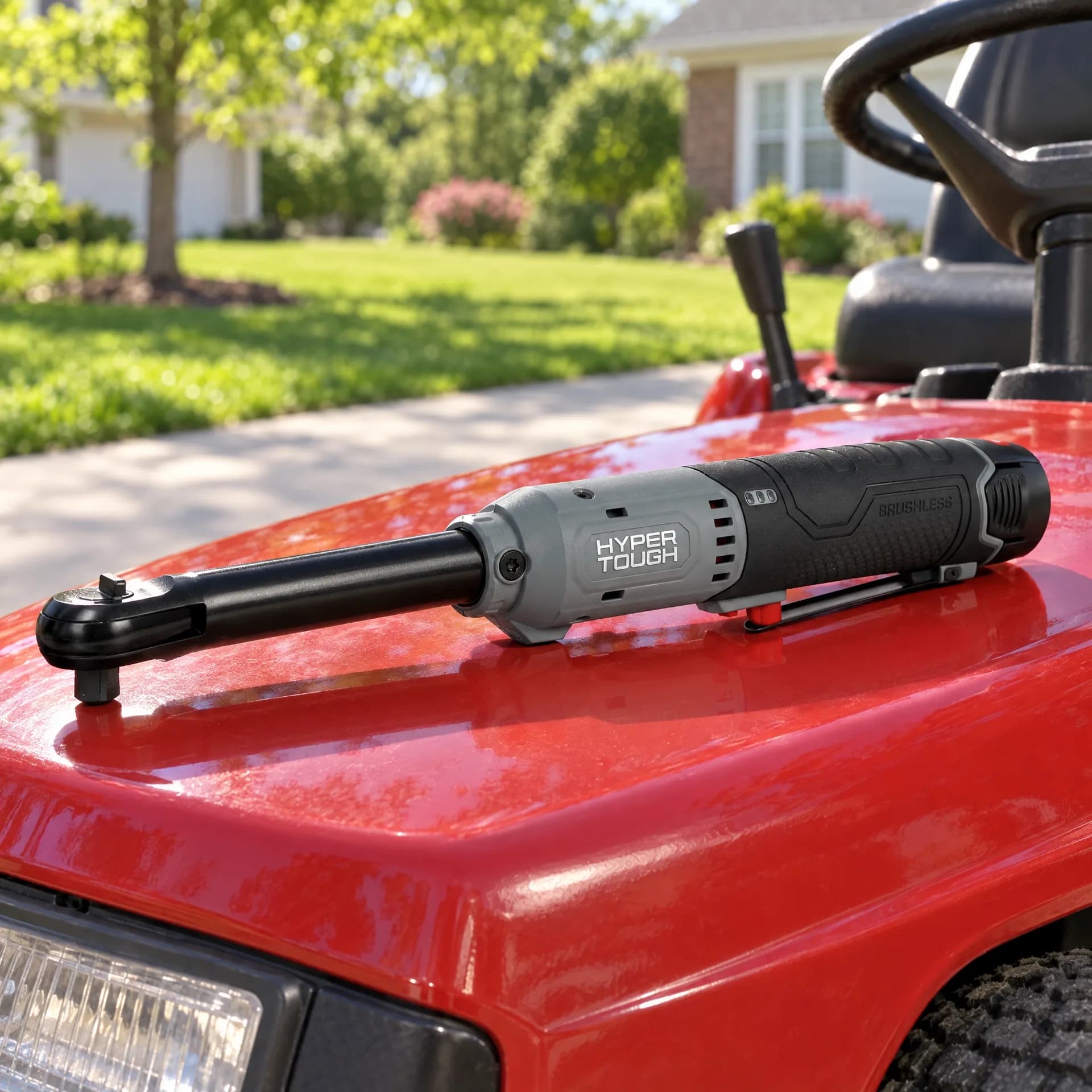Hyper Tough extended reach ratchet wrench resting on the glossy red hood of a riding lawn mower in a suburban front yard